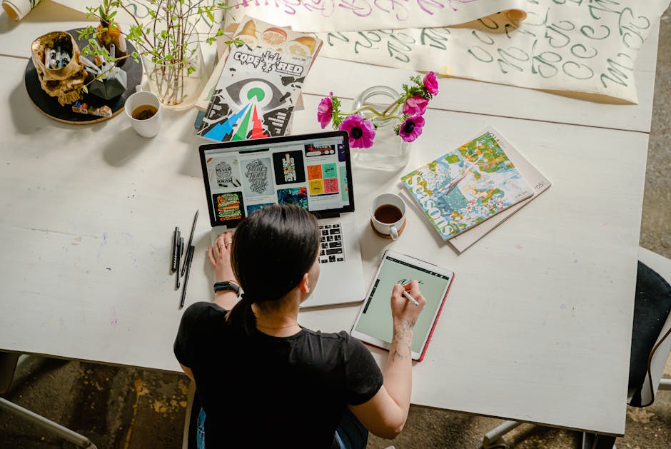 pexels-photo-4348401-4348401 Artistic workspace featuring calligraphy and digital design on a tablet and laptop.