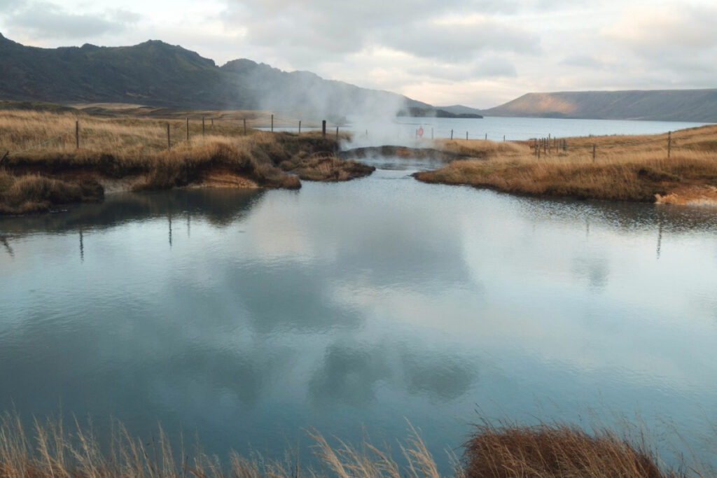Still river winding between banks under a soft sky